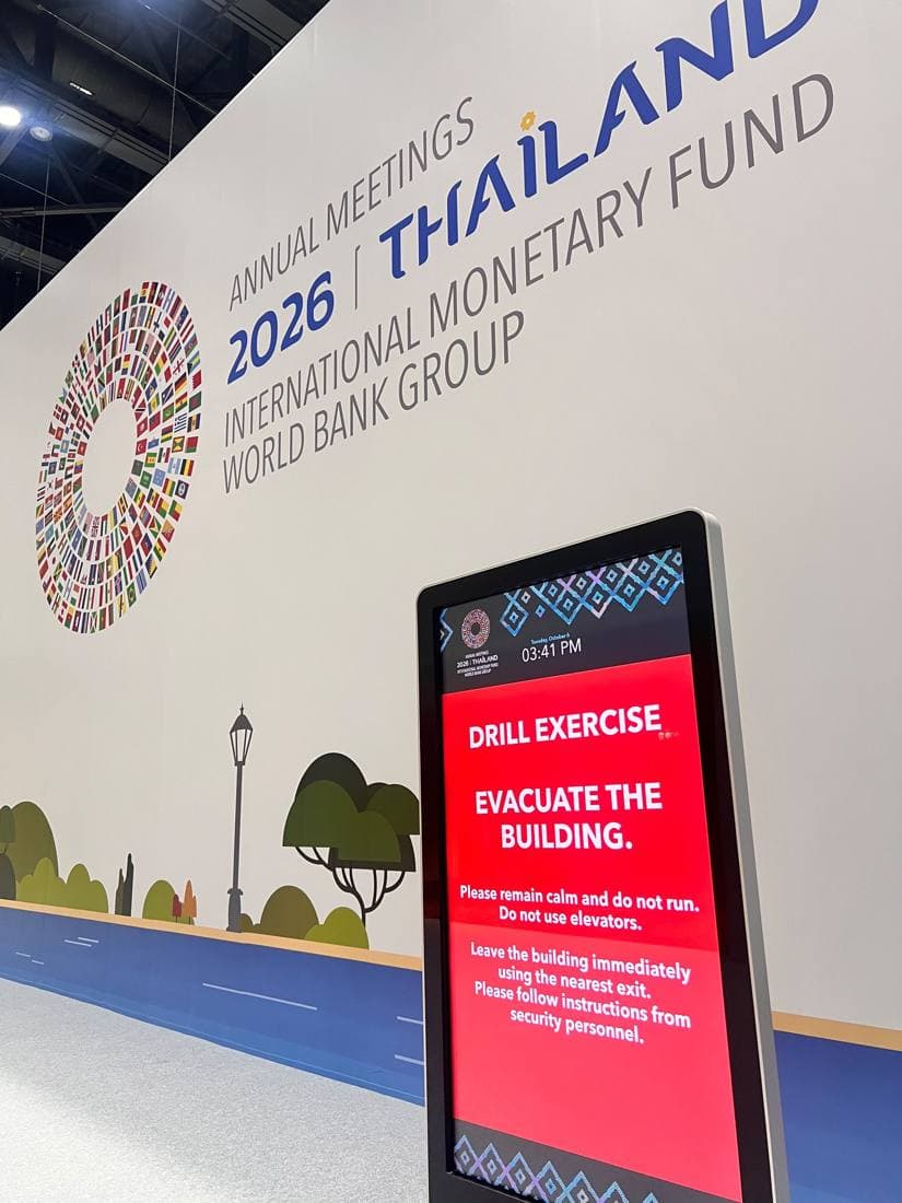 Digital sign reading Drill Exercise, Evacuate the Building, in front of the Annual Meetings 2026 Thailand backdrop